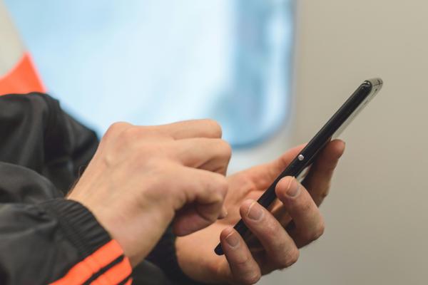 young man's hands using a mobile