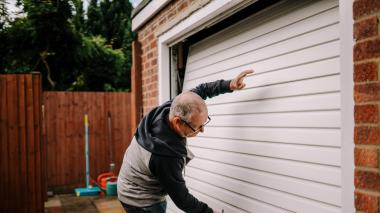 a man is closing his white garage door