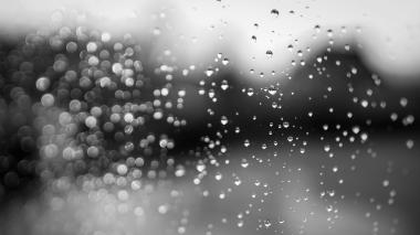 raindrops on a window with a dark background